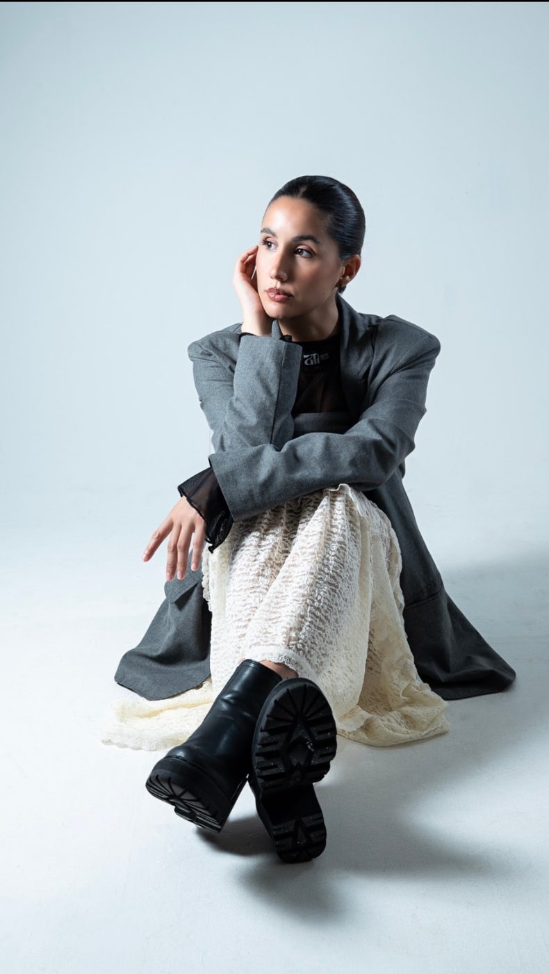 Seated studio portrait of a woman in a gray coat