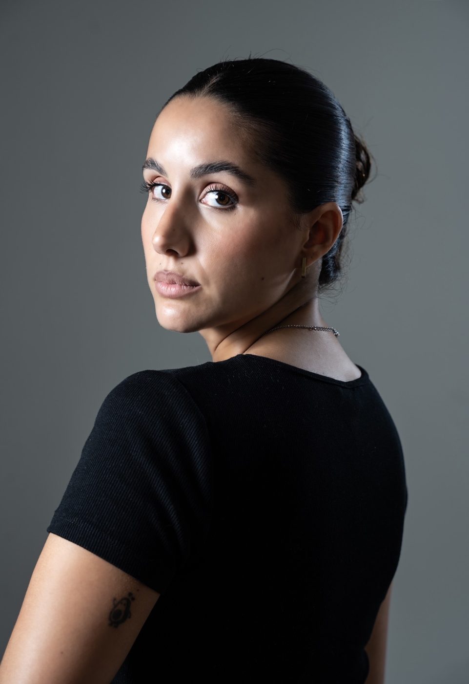 Over-the-shoulder portrait of a woman in black